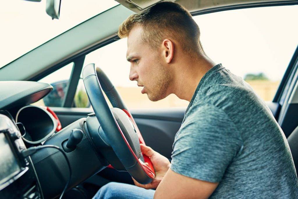 Man Listening For Strange Sound Coming From Car